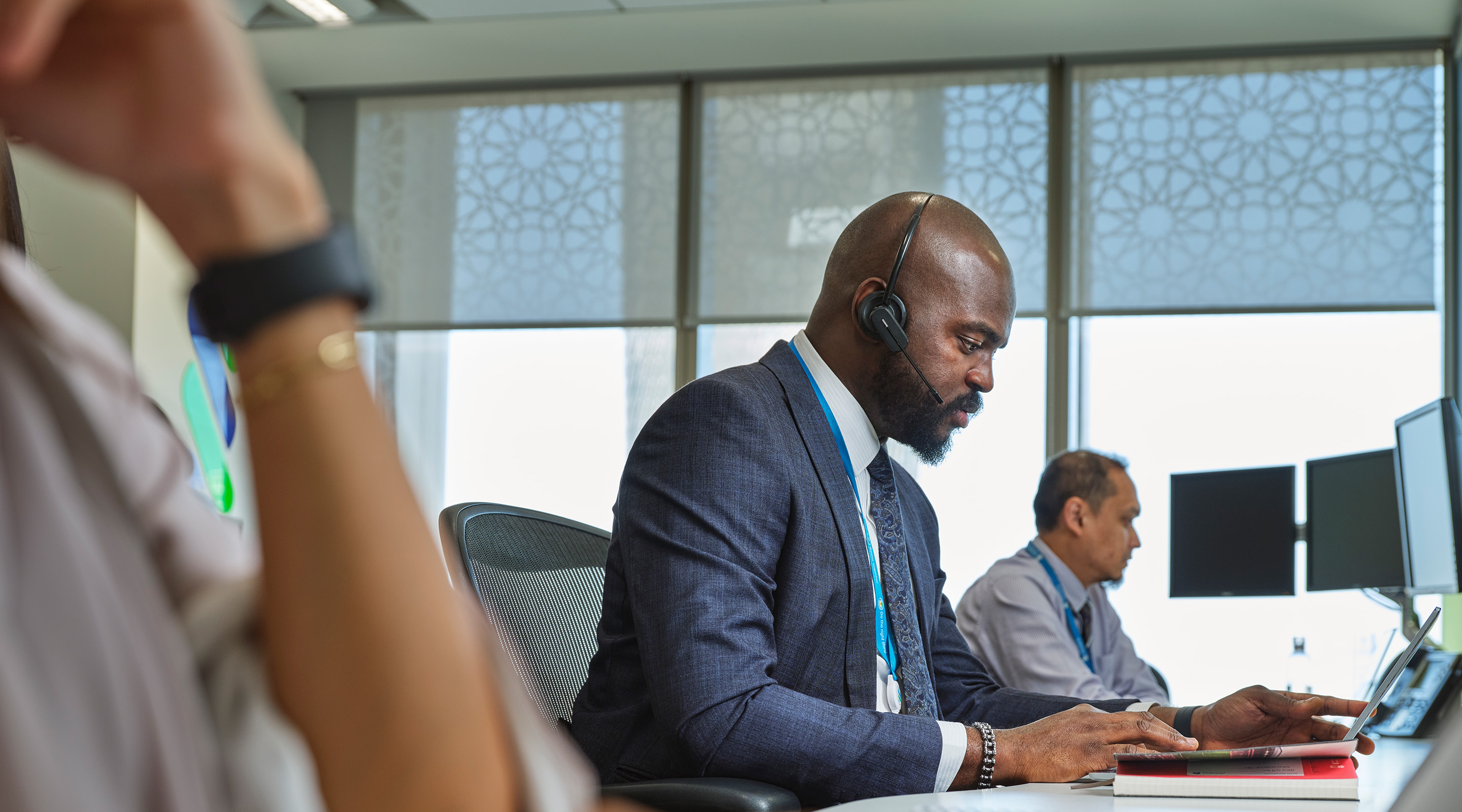 Consulting regulatory materials while on a call in a Standard Chartered office